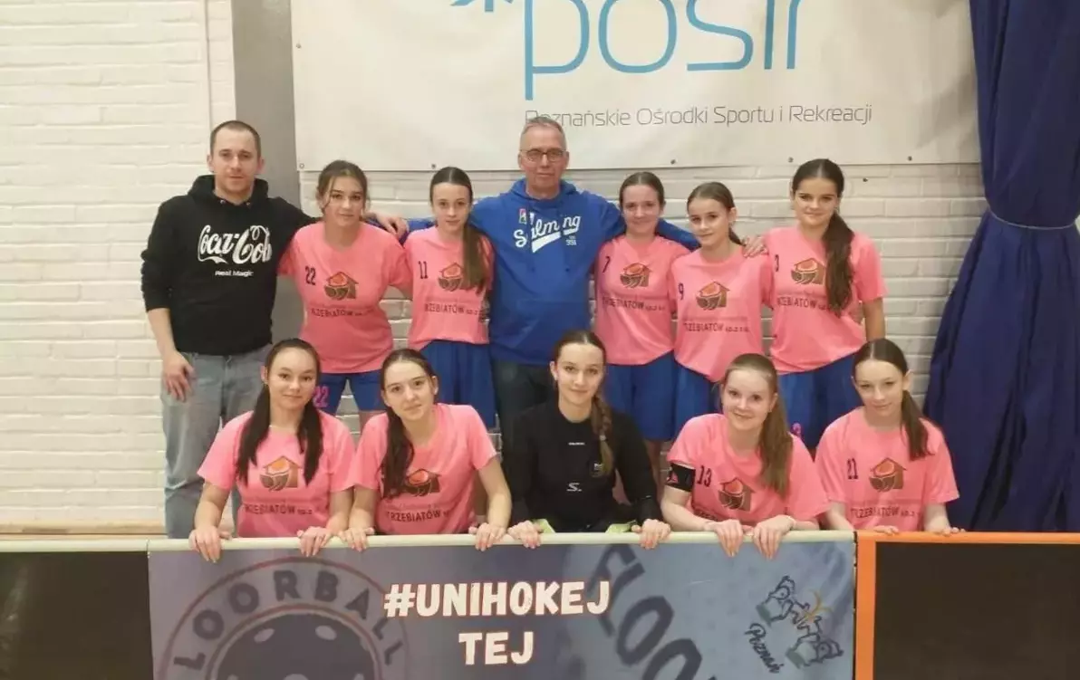 Plakat informujący o Mistrzostwach Polski w unihokeju, które odbędą się w hali Mrzeżyńskiego Centrum Sport/na zdjęciu widoczna drużyna SUS Travel Jedynki Trzebiatów w kategorii Juniorek Młodszych 